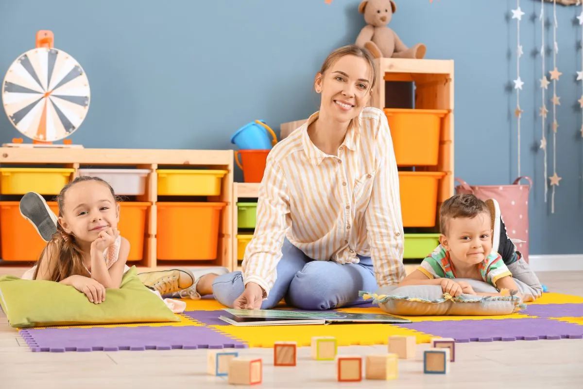 nanny and little children playing at kids playroom