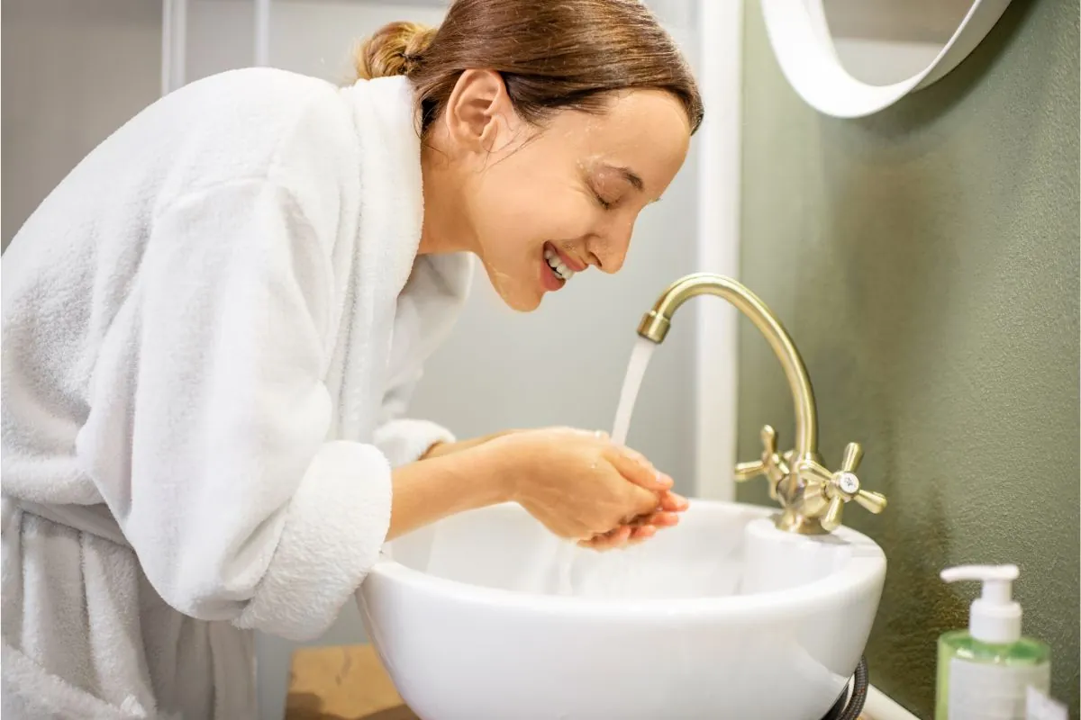 woman washing face in the bathroom