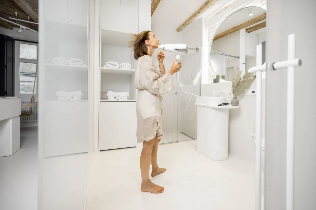 woman using hairdryer in the bathroom